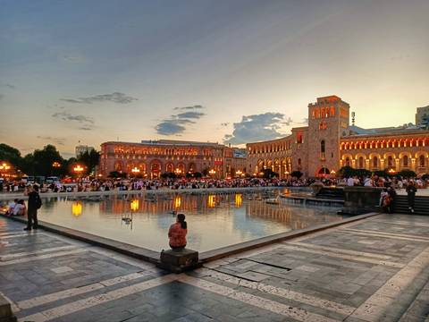 Evening scene at Republic Square Yerevan with fountains and crowds under golden light