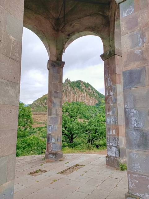 Rugged cliff face framed between two stone pillars in lush surroundings
