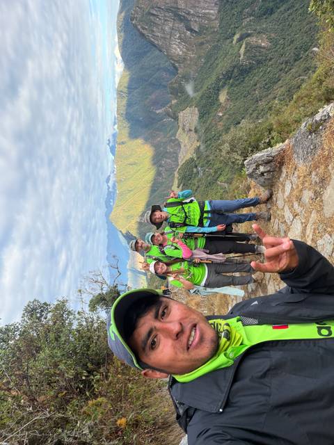 Group of hikers posing on the Inca trail with expansive mountain backdrop