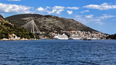 View across Dubrovnik’s bay with Franjo Tuđman bridge and cruise ships under a bright sky