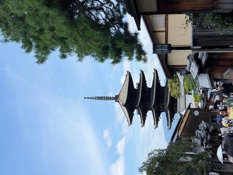 Historic wooden Yasaka Pagoda towers over narrow traditional streets lined with visitors.