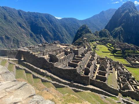 Classic wide view of Machu Picchu’s stone ruins cascading down green terraces against jungle peaks