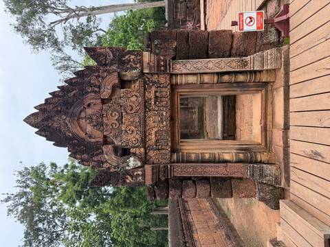 Red sandstone entrance frame with ornate carvings at Banteay Srei temple complex