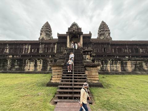 Angkor Wat stairway scene with several visitors posing and walking on steps