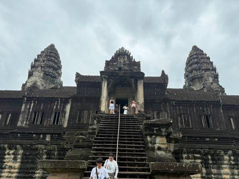 View looking up Angkor Wat entrance with visitors at the top of the wooden staircase