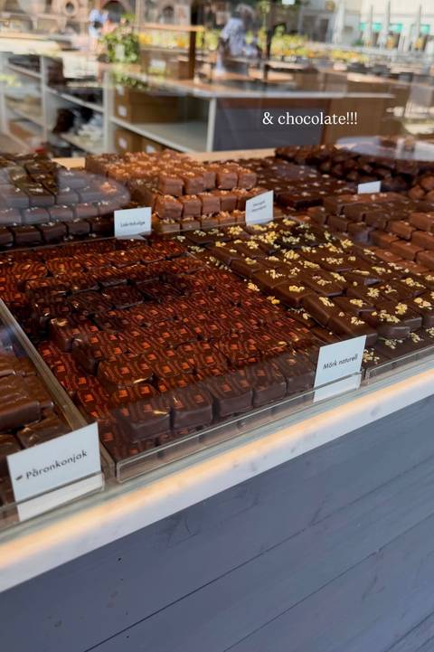 Display case packed with rows of assorted gourmet chocolates neatly arranged for sale.
