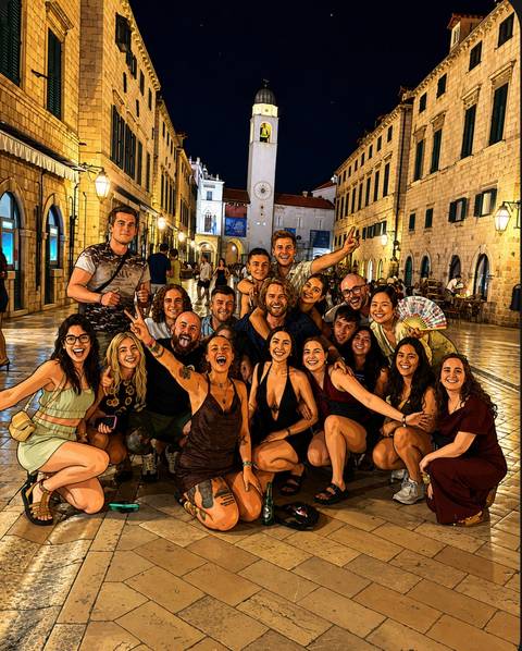 Stylized cartoon-like night portrait of a travel group celebrating on a historic cobbled street.