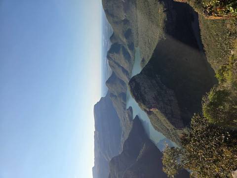 Panoramic viewpoint over Blyde River Canyon with deep green valleys and winding blue reservoir.
