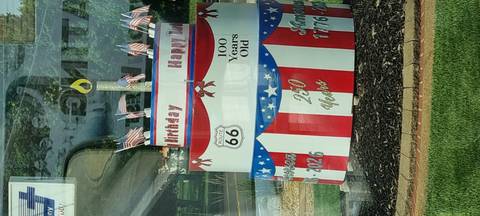 Patriotic tiered birthday cake sculpture decorated with Route 66 emblems and US flags.