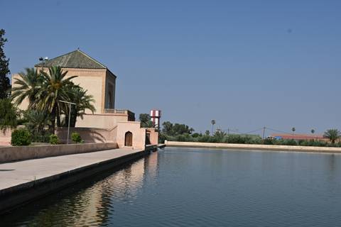 Historic pavilion beside a long rectangular pool at Menara Gardens in Marrakesh.