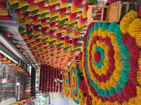Vibrant display of multicolored incense sticks arranged in geometric patterns at a workshop