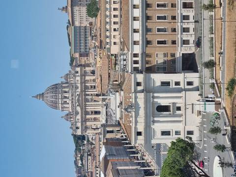 Classic skyline view of St. Peter’s Basilica dome towering above the streets of Vatican City.