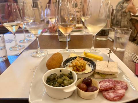 Wine glasses and small Sicilian tapas dishes arranged for a tasting session at a table.