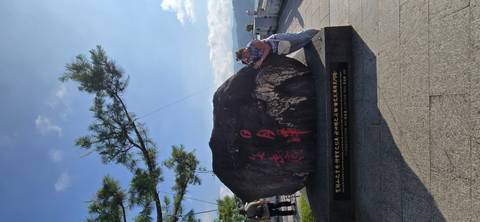 Tourists posing with the famous Sun Moon Lake inscribed boulder viewpoint under blue sky