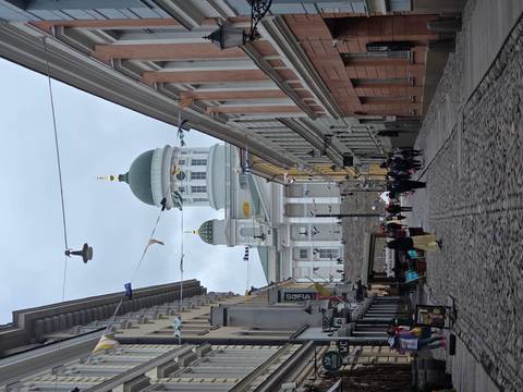 Cobblestone street leads to the iconic green-domed Helsinki Cathedral framed by historic buildings.