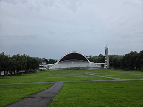 The sweeping white shell stage of Tallinn Song Festival Grounds sits in a vast green park.