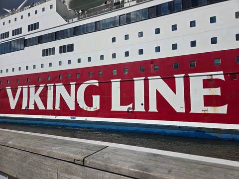 Close-up of the bold red and white hull of a Viking Line cruise ship at dock.