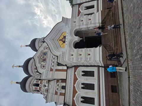 The ornate onion-domed Alexander Nevsky Cathedral towers above visitors on cobblestone streets.