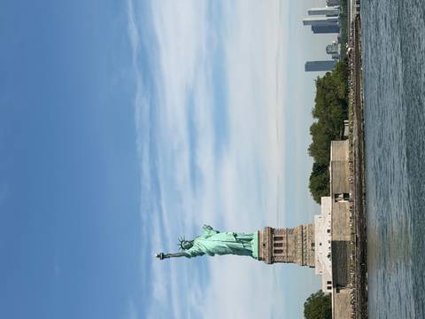 Iconic Statue of Liberty rises above New York Harbor under a clear sky.