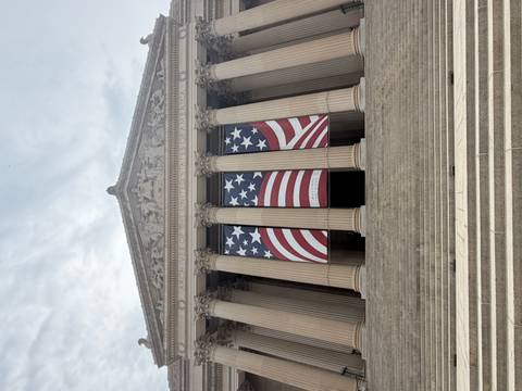 Broad steps leading to the National Archives lined with large patriotic banners under a classical pediment.