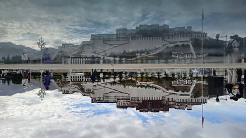 Potala Palace majestically reflected in a still pool under a textured sky.