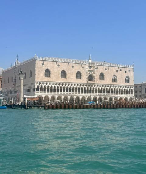 The pink-tiled Doge's Palace fronting the turquoise lagoon waters of Venice.