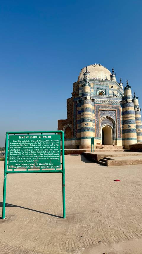 Information sign for Tomb of Baha al-Halim in front of ornate blue shrine entrance.