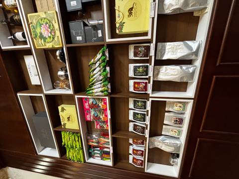 Shelves filled with colorful packaged coffees, teas and gifts inside a shop or café.