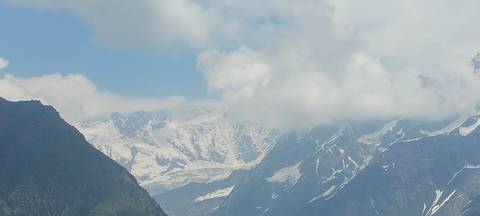 Snow-covered Himalayan peaks rising above cloud layers and deep valleys.