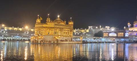 Golden Temple illuminated at night reflecting in the serene water tank.