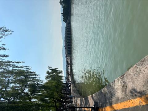 Long arched stone bridge stretching across tranquil lake waters at Beijing’s Summer Palace.