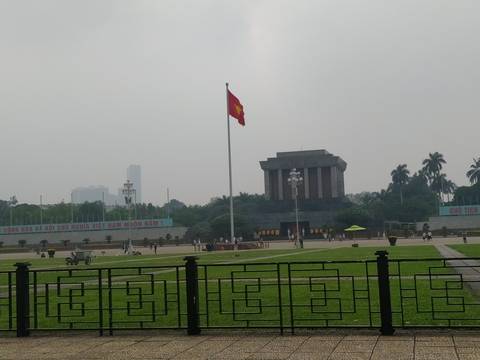 Ho Chi Minh Mausoleum and flagpole on an overcast day in Hanoi’s Ba Dinh Square.