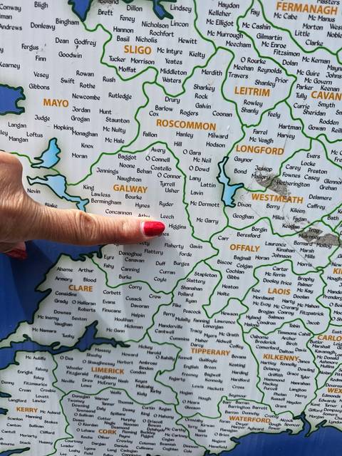 Close-up of a travel map of Ireland with a hand pointing to Galway county