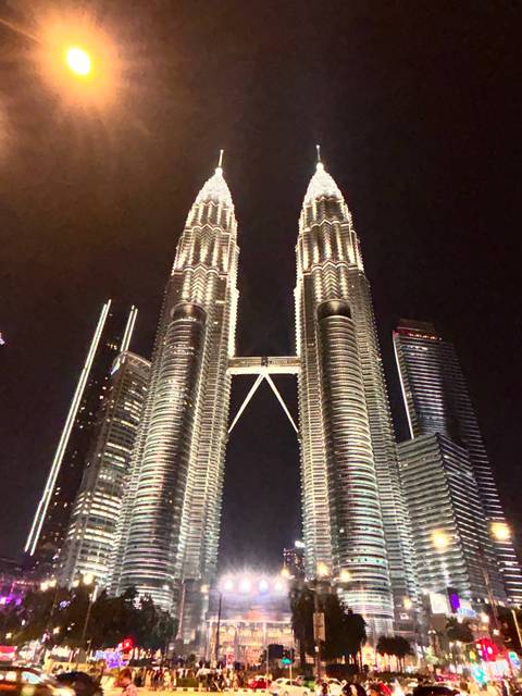 Night view of Petronas Twin Towers with city lights, slightly grainy