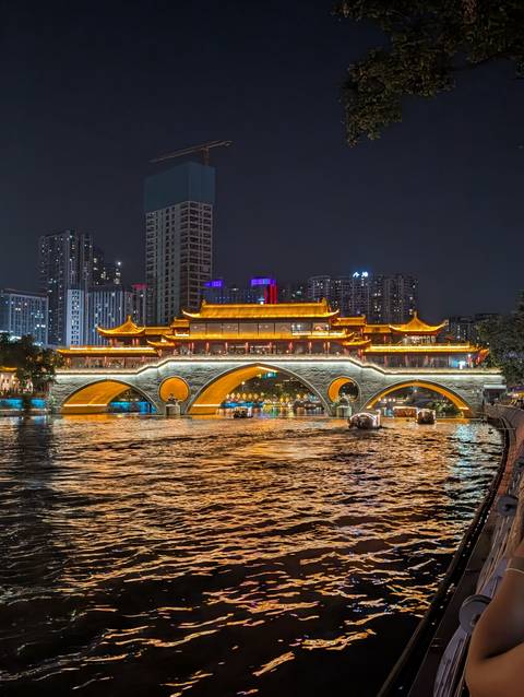Anshun Bridge and surrounding city lights reflect vividly on Chengdu’s river at night.
