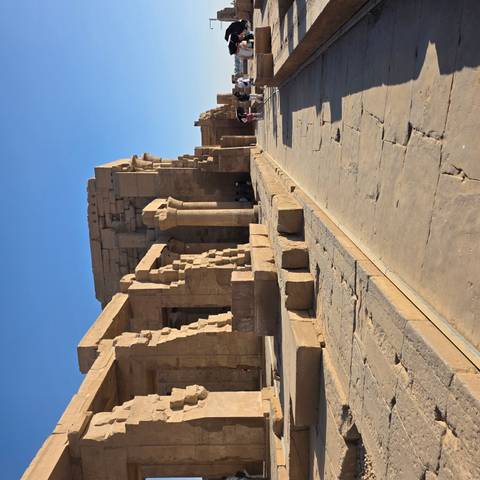Stone columns and walls of an ancient Egyptian temple complex lit by afternoon sun