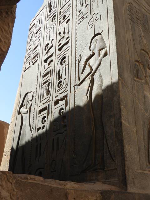 Close detail of hieroglyphs and cartouches carved into a towering stone obelisk