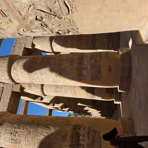 Massive engraved columns at Karnak casting deep shadows in strong sunlight