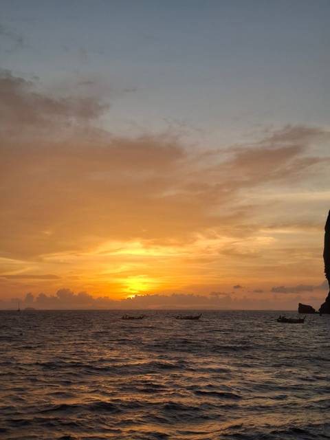 Golden sunset sky with scattered clouds and a warm glow near the horizon.