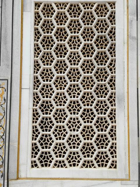 Detailed view of a geometric honeycomb marble screen showcasing fine Indian stone lattice work.