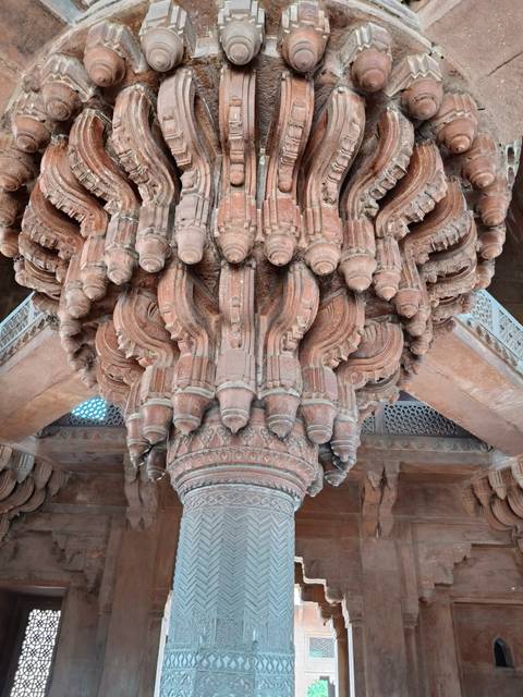 The ornate central pillar of Diwan-i-Khas at Fatehpur Sikri displays intricate Mughal carving.