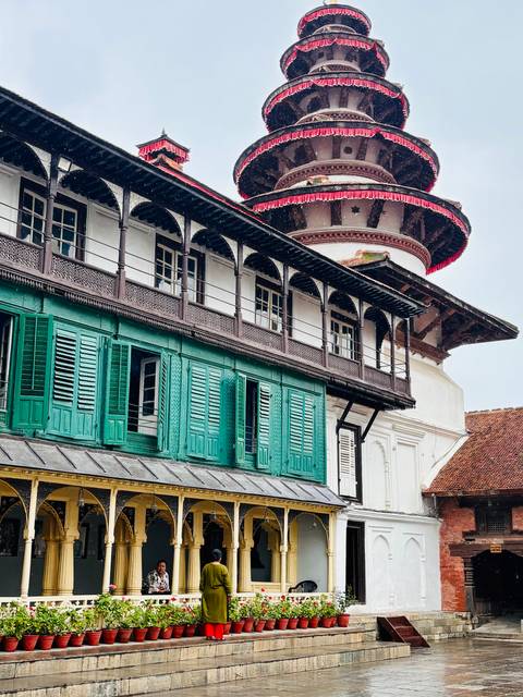 Historic Kathmandu building with teal shutters and intricate timber balconies.