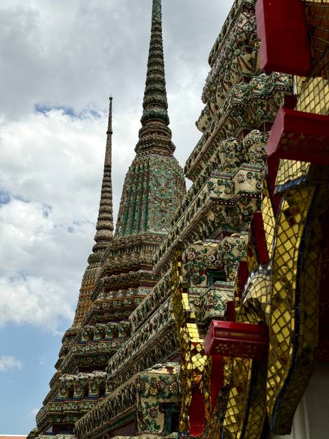 Close view of intricate mosaic-covered spires at Wat Arun.