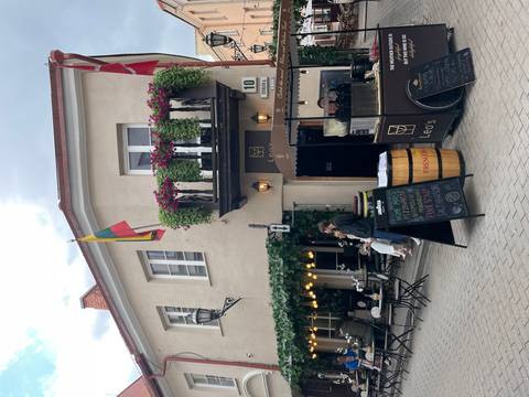 Cozy street café with hanging vines, national flags and chalkboard menus on a quaint corner building