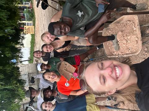 Cheerful volunteers pose with construction tools at a community project site