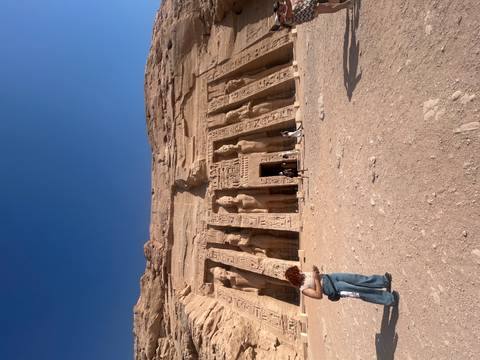 Colossal rock-cut statues at Abu Simbel temple with visitors at the base