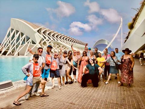 A cheerful tour group posing in front of Valencia’s futuristic City of Arts and Sciences complex by the reflecting pool.