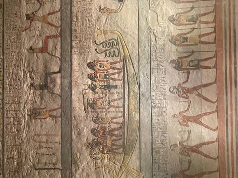 Well-preserved ancient Egyptian wall paintings showing deities and figures aboard a ceremonial boat.