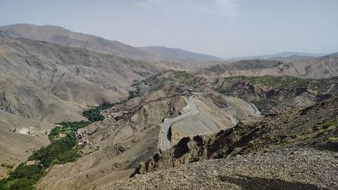 Sweeping view over twisting mountain road winding through the rugged High Atlas range.