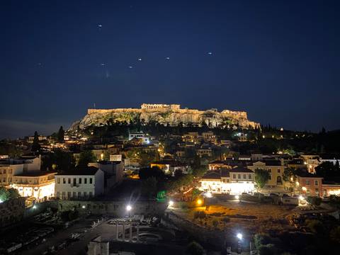 Night panorama of the illuminated Acropolis hill above Athens rooftops